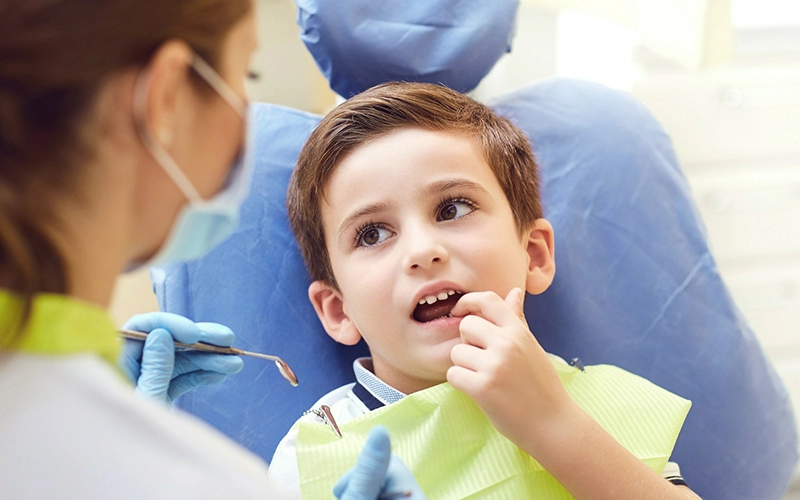 chłopiec siedzący na fotelu dentystycznym